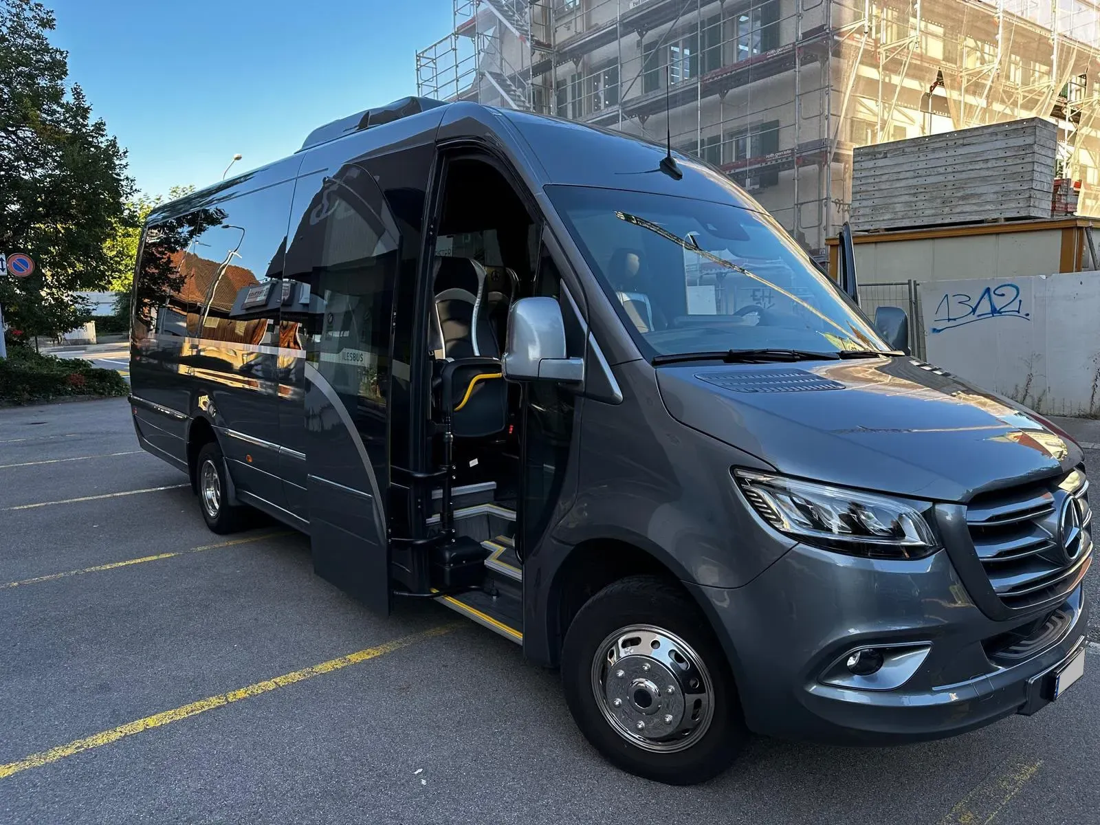 Grey Mercedes Sprinter minibus with the passenger door open