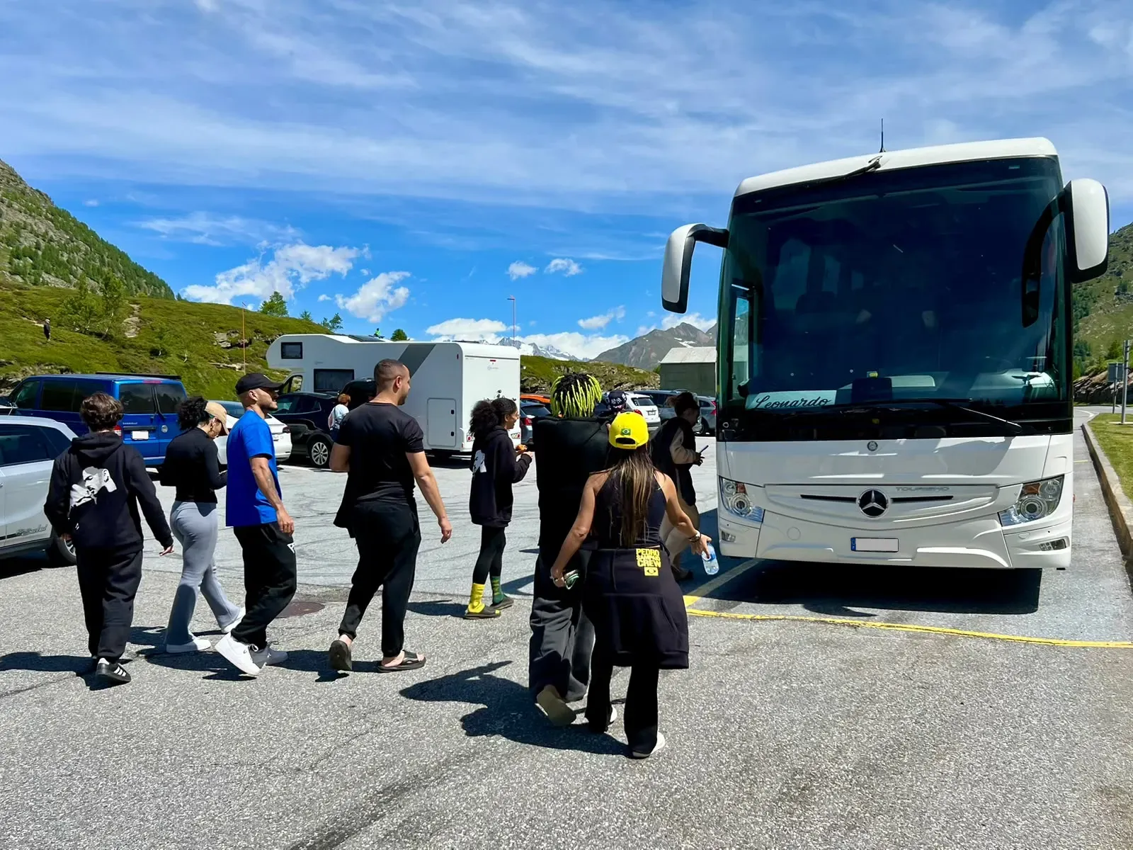 Group walking to a Leonardo Travel coach in a park in the Alps