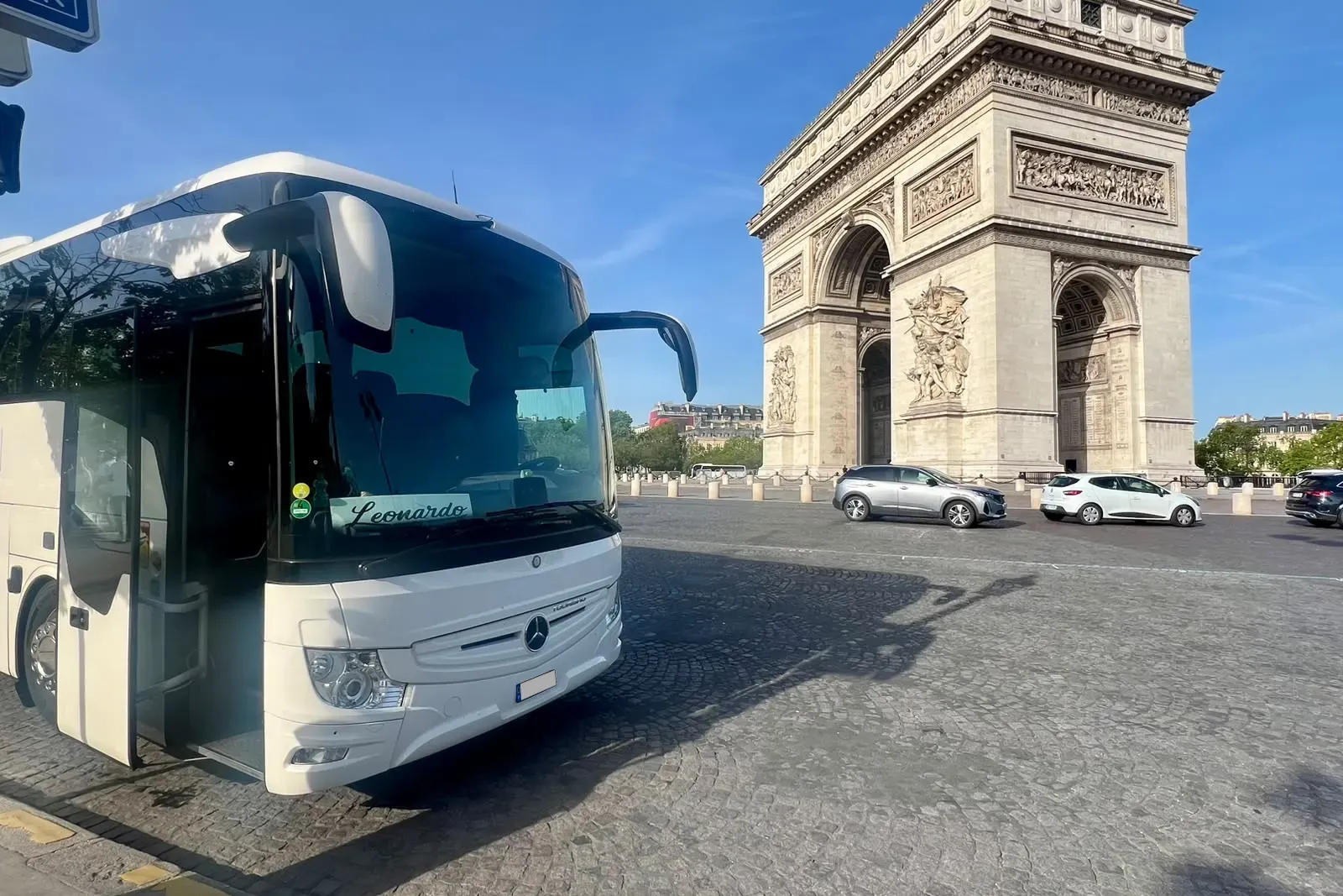 Autocarro da Leonardo Travel junto ao Arco do Triunfo, em Paris, num dia de céu azul