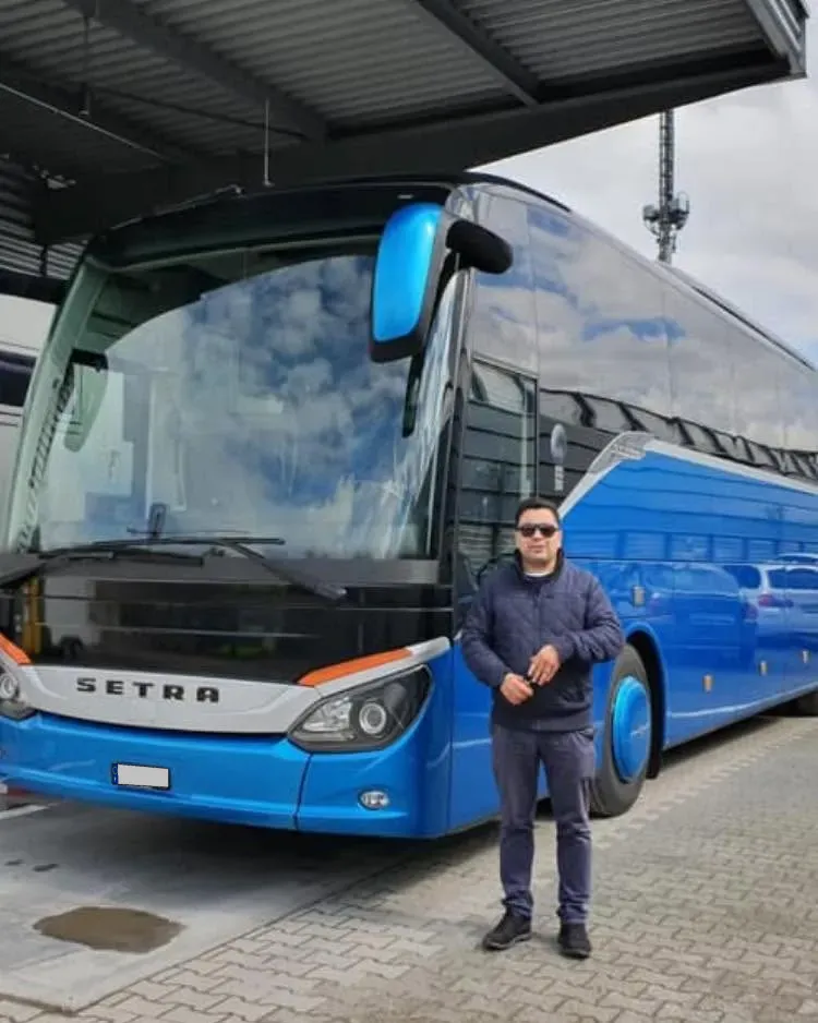 Motorista da Leonardo Travel ao lado de um autocarro Setra azul