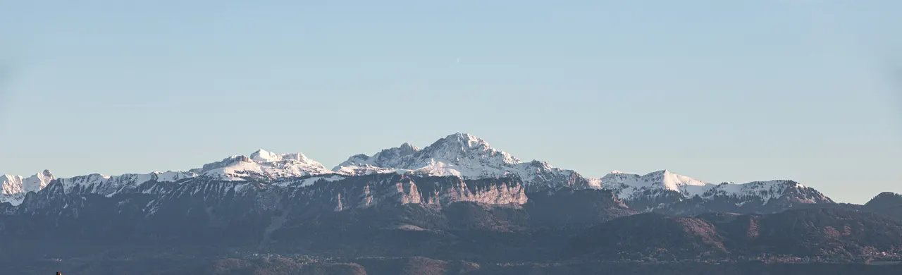 Landschaft der Schweizer Alpen mit verschneiten Gipfeln am Horizont